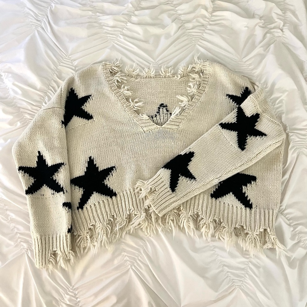 Cream and navy star knit sweater with distressed detailing. Perfect for winter!